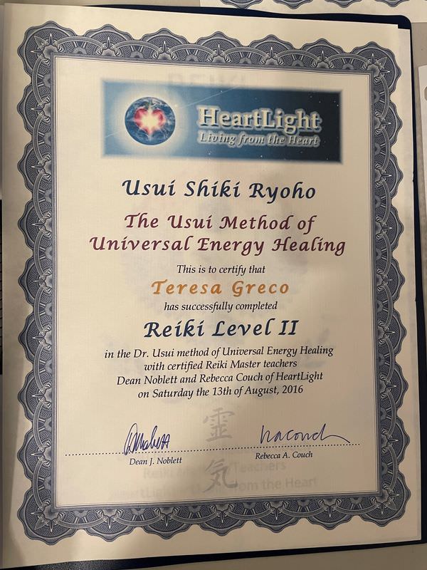 The image is a certificate indicating that the individual named Teresa Greco has successfully completed "Reiki Level II" in the Usui method of Universal Energy Healing. The certificate includes the name "HeartLight" with the tagline "Living from the Heart," along with decorative elements and signatures from Dean J. Noblett and Rebecca Couch. It is dated Saturday, August 13th, 2016.