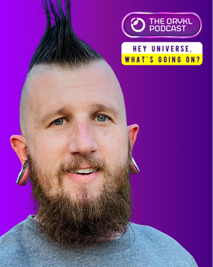 The image features a man with a prominent mohawk hairstyle. He has a full beard and both ears are adorned with large gauges. The background is a gradient of purple, and there’s text at the top indicating it's related to "The Orykl Podcast," along with a greeting that says, "Hey Universe, what's going on?" The man is wearing a gray shirt.