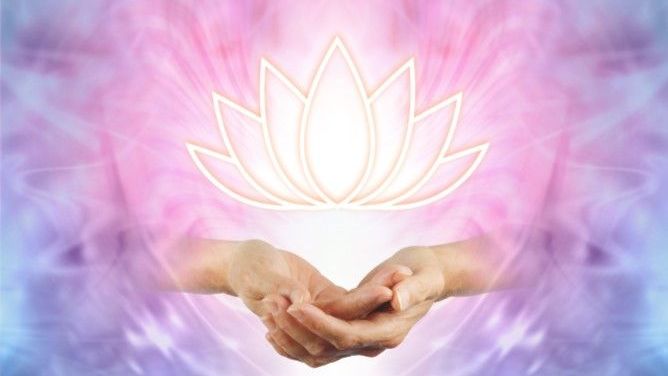 The image depicts two hands positioned with palms up, seemingly offering something. Above the hands, there is a stylized lotus flower illuminated with a soft white light. The background features a blend of pastel colors, primarily pink and blue, creating a dreamy and ethereal atmosphere. The overall composition conveys a sense of calmness and spirituality.