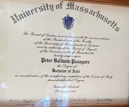 The image shows a diploma from the University of Massachusetts. It includes the official seal of the university at the top and is framed. The diploma states that it was awarded to Peter Baldwin Panagore for receiving a Bachelor of Arts degree. It also mentions that the degree was given in consideration of satisfactory completion of the course of study and is dated February 1988.