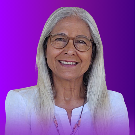 The image features a woman with long, straight gray hair, wearing glasses and a white top. She is smiling and appears to be in a well-lit setting. The background is a gradient of purple shades, enhancing her presence in the image.