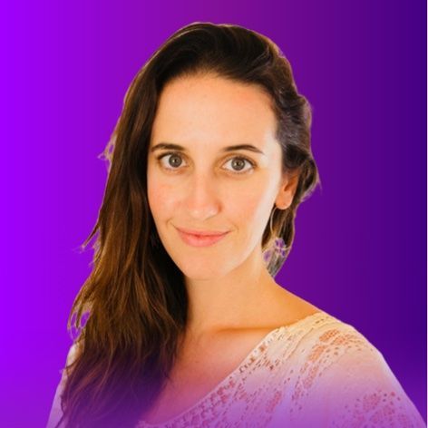 The image features a person with long, dark hair, smiling gently. They are wearing a light-colored top with a textured pattern. The background is a gradient of purple hues, giving a vibrant and soft appearance. The focus is primarily on the person's face and upper body.
